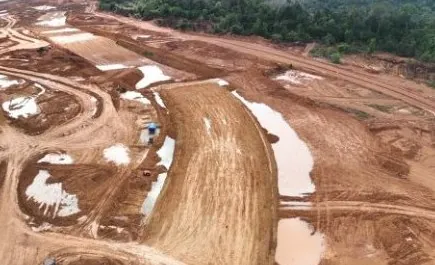 Vista aérea de aterro em curva, com poças d’água e caminhos de serviço em terra vermelha
