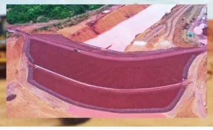 Vista aérea de lagoa revestida, com taludes em terra vermelha ao redor