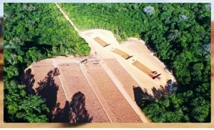 Vista aérea de talude conformado em clareira aberta na floresta, com máquinas no topo