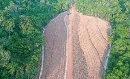 Vista aérea de faixa de talude em conformação aberta entre a floresta, com canaletas nas bordas