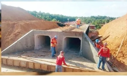 Equipe uniformizada executando bueiro celular duplo em concreto